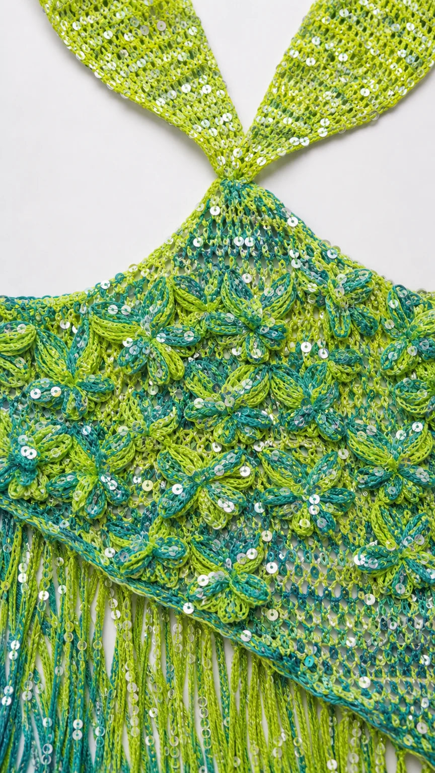 Close-up detail of lime green sequin crochet knit texture and fringe hem