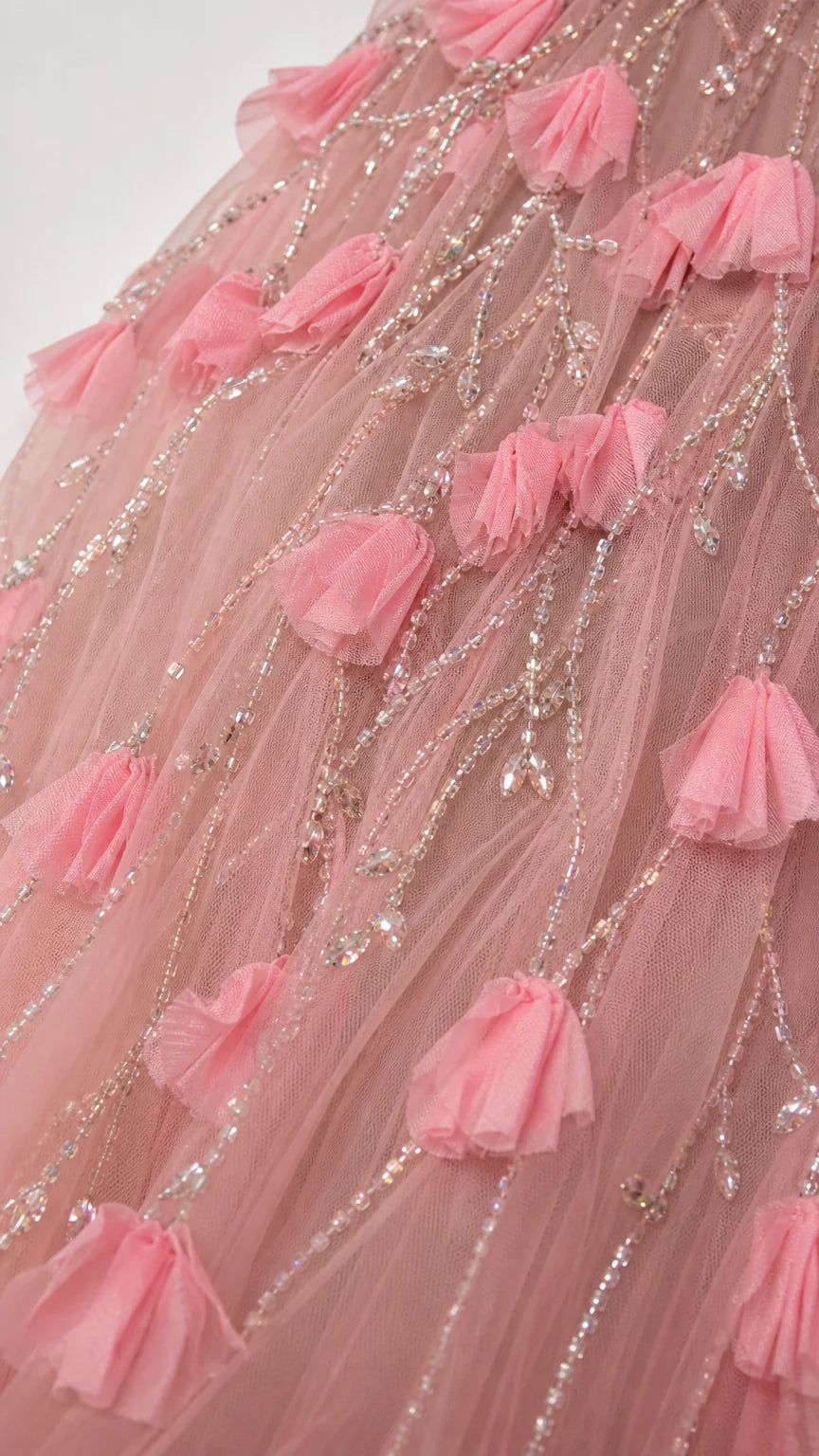 Close up of 3D pink floral petal appliqués and sequin beadwork on tulle